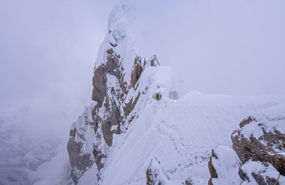 Looking back at our bivouac in the cornice as the storm clears briefly